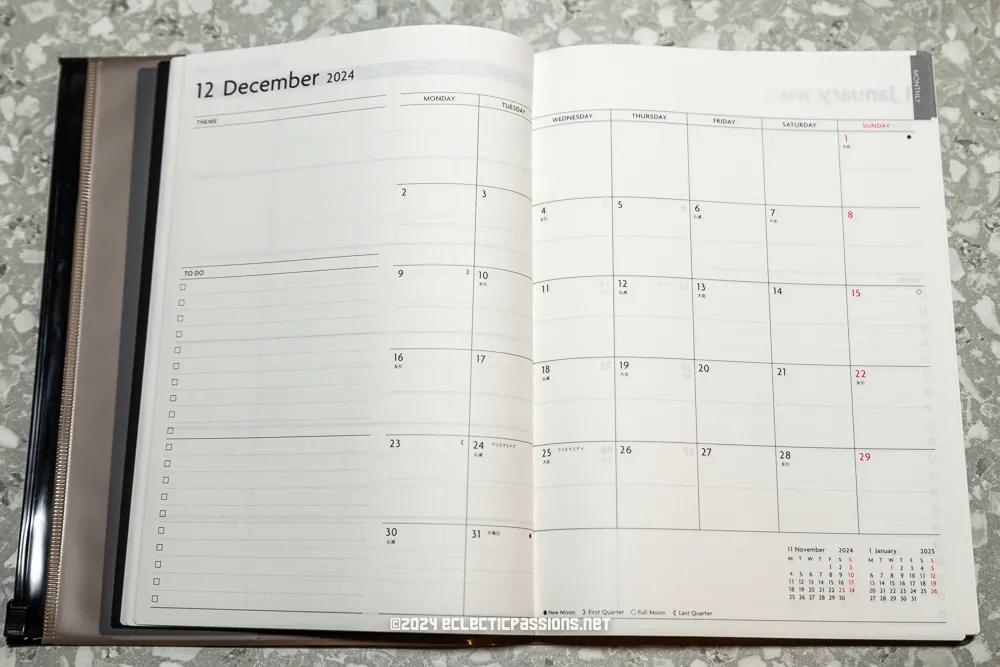 An open planner showing December 2024. The left page features a lined section for notes and to-do lists. The right page displays a monthly calendar grid for December. The planner is placed on a speckled surface.