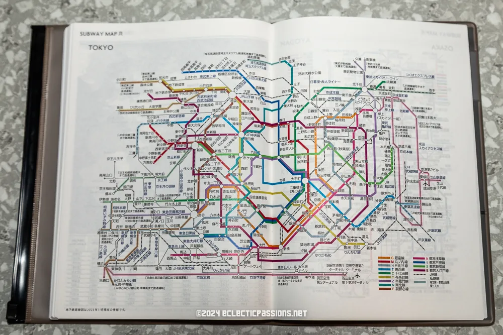 An open book displaying a detailed map of the Tokyo subway system. The map features various colored lines representing different train routes, station names in both Japanese and English, and a key for line identification at the bottom.