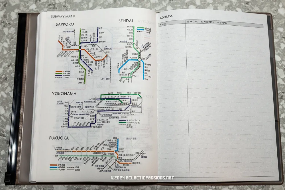 An open notebook displaying detailed subway maps of Sapporo, Sendai, Yokohama, and Fukuoka on the left page. The right page has sections for name, phone, address, and email, with no entries.